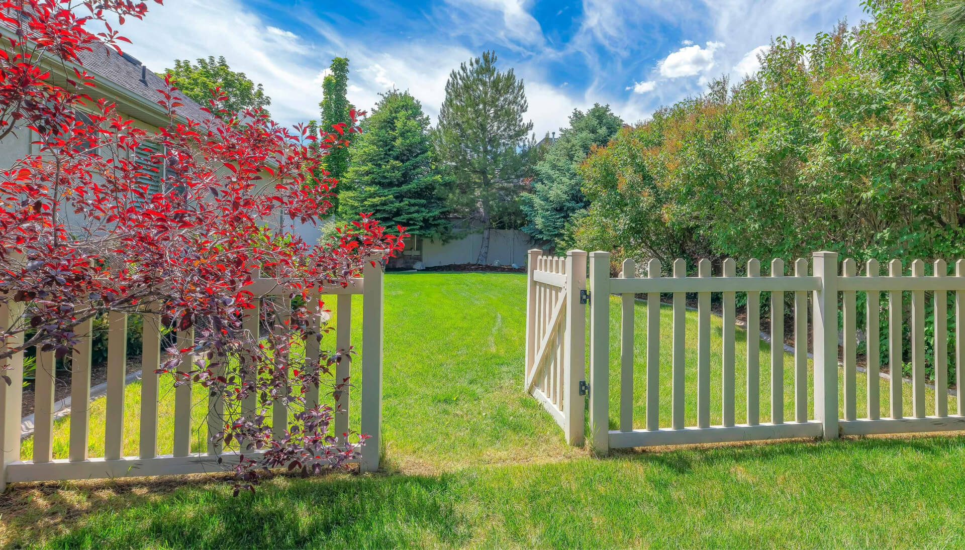 A functional fence gate providing access to a well-maintained backyard, surrounded by a wooden fence in Baltimore